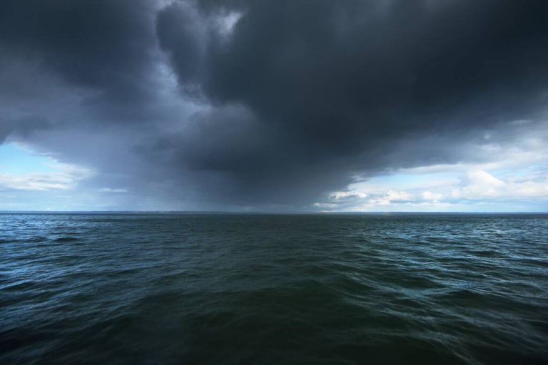 Stormy blue sky above the Baltic sea. Dramatic glowing clouds. Hanko Peninsula, Finland. Dark seascape. Nature, environment, climate change, weather Impact of Climate Change on Weather