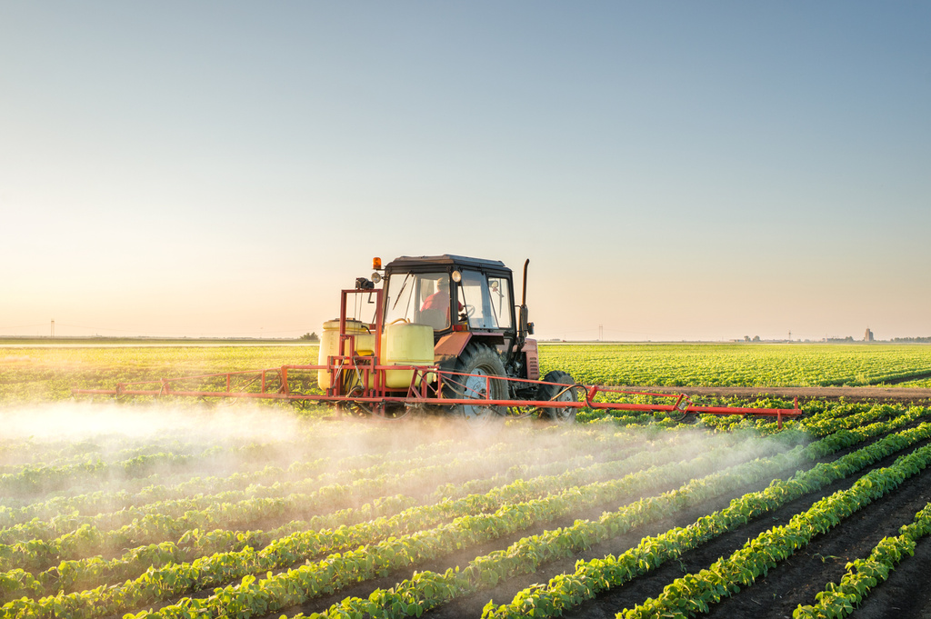 Tractor spraying soybean