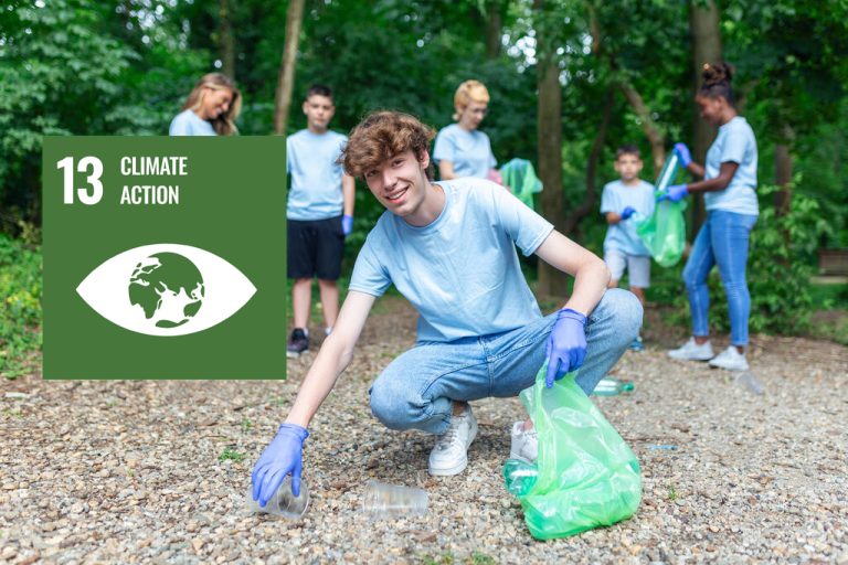 Volunteers gathered for a charity event focused on cleaning the environment. The group consisted of happy individuals enthusiastic about making a difference. They collected garbage to promote ecology and protect nature. The event emphasized the importance of volunteering for a good cause. Sdg13